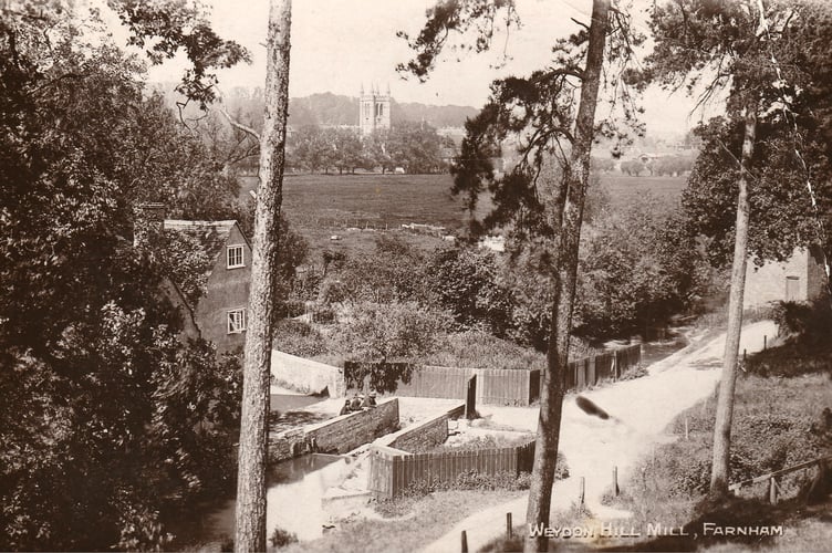 The picturesque former Weydon Hill Mill, overlooking Farnham's flood meadows and St Andrew's Church in the distance