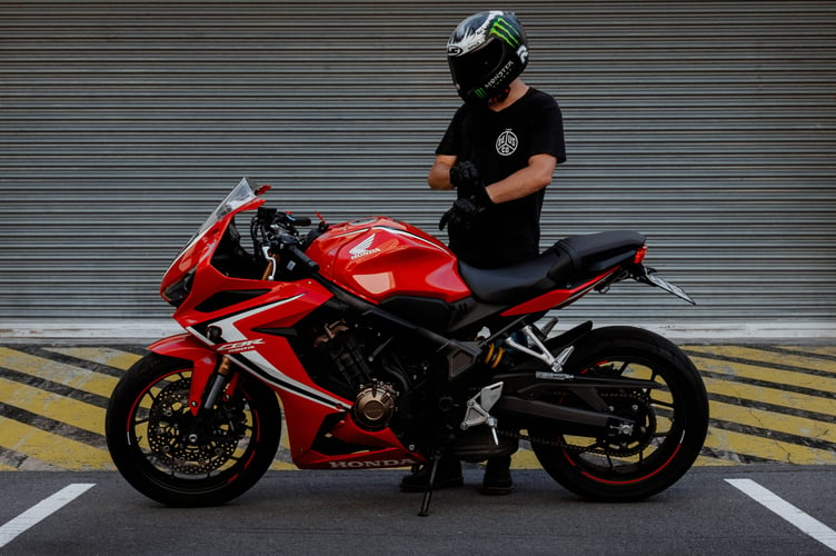 man in black and red motorcycle helmet riding red and black sports bike