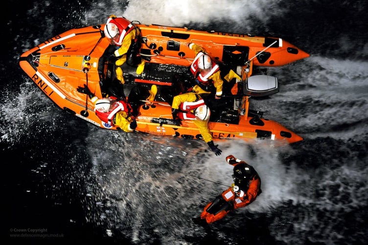 RNLI Lifeboat Crew Reaching Out to Royal Navy Rescue Winchman